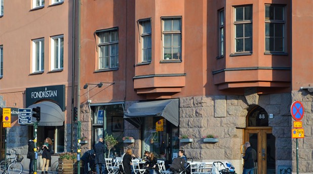 Bostadshus på gata med uteservering. lgh-stockholm_asa-larsson_740x413